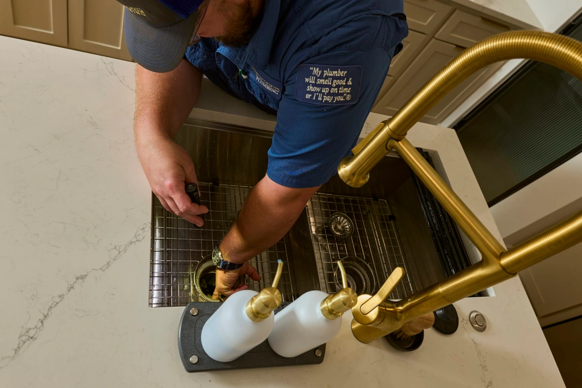 A licensed plumber performs a professional drain repair on a kitchen sink.